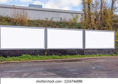 Three White Billboards By The Pavement With Grass And Trees In London Cloudy Sky