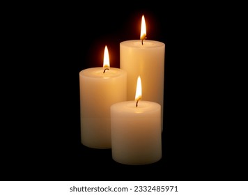 Three white candles with different size burning on black background.