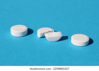 Tres pastillas blancas yacen sobre un fondo azul.