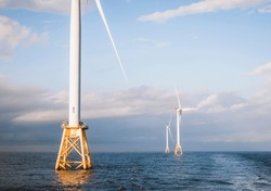 Three Wind Turbines At Sunset In The Middle Of The Ocean