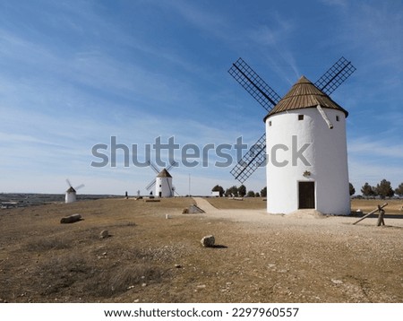 Three windmills on La Mancha land. Sunny day and blue sky with clouds. Mota del cuervo. Foto stock © 