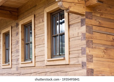 Three windows on a wooden building such as house, cottage, logde, cabine or challet.