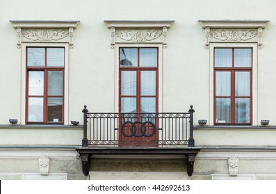Three windows in a row and balcony on facade of urban apartment building front view, St. Petersburg, Russia