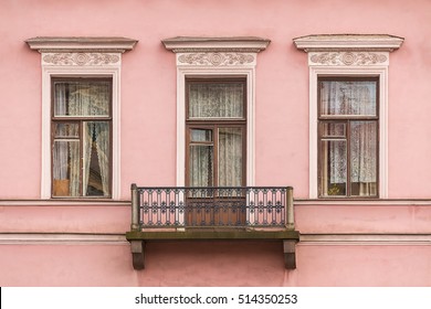 Three windows in a row and balcony on facade of the urban apartment building front view, St. Petersburg, Russia