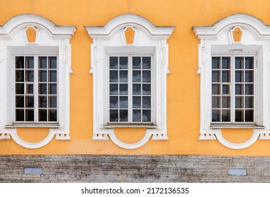 Three Windows In White Frames And Decoration Of Yellow Wall. Classic Architecture Details. Background Photo Texture