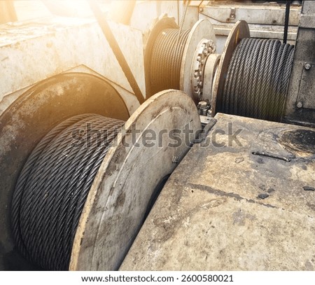 Three wire drums mounted on a crane. Wire rope sling or cable sling on the drum of a crane reel or winch reel of a lifting machine in heavy industry. Close-up photo of wire on crane drum
