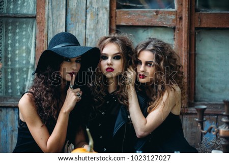 Three witches looking to the camera