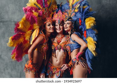 Three Woman in brazilian samba carnival costume with colorful feathers plumage