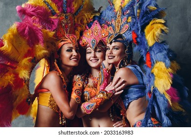 Three Woman In Brazilian Samba Carnival Costume With Colorful Feathers Plumage.