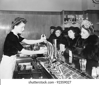 Three Woman And A Man Sitting In A Soda Fountain