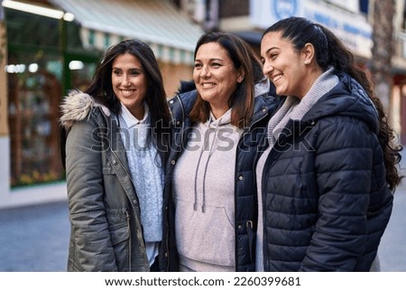 Three woman mother and daughters standing together at street