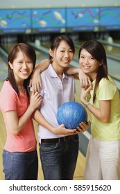 Three Women At Bowling Alley, Standing Side By Side, Smiling At Camera