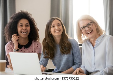 Three Women Different Ethnicity And Ages Looking Away Laughing Sitting At Workplace Gather At Corporate Meeting Take Break Telling Joke Stories Anecdotes, Friendly Collective And Fun At Work Concept