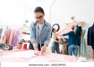 Three women at garment factory. They are taking measurements and making cut-out. They are happy and fashionable. - Powered by Shutterstock