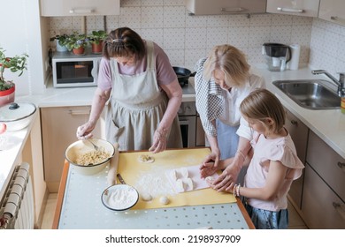 Three Women In The Kitchen Are Cooking Pies Together.