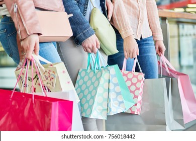 Three women with many shopping bags as a symbol of consumption and purchasing power