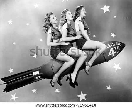 Three women sitting on a rocket