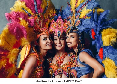 Three Women Smiling Portrait In Brazilian Samba Carnival Costume With Colorful Feathers Plumage.