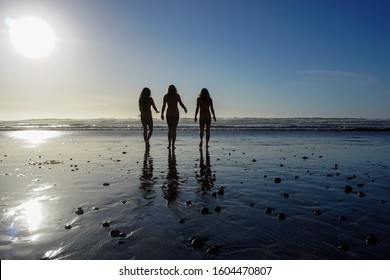 Three Women Walk Into The Ocean.