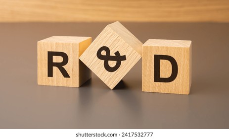 three wooden blocks with the abbreviation R and D - Research and development symbolizes the journey of innovation. 