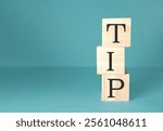 Three wooden blocks stacked on top of each other with the word tip written on them. Concept of importance and value, as the word tip is often associated with giving feedback or advice