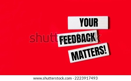 Three wooden blocks with the text YOUR FEEDBACK MATTERS on a bright red background. Copy space