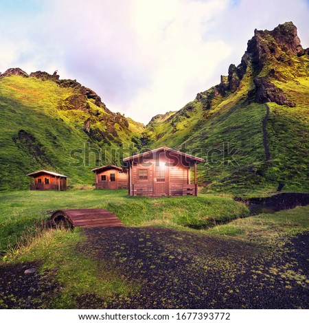 three wooden cabins at Thakgil campsite in Iceland in early morning at sunrise