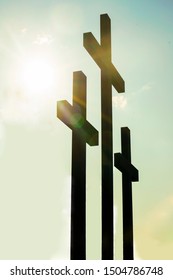 Three wooden crosses stand against a dramatic evening sky with radiant beams penetrating clouds. Great for Easter Sunday!