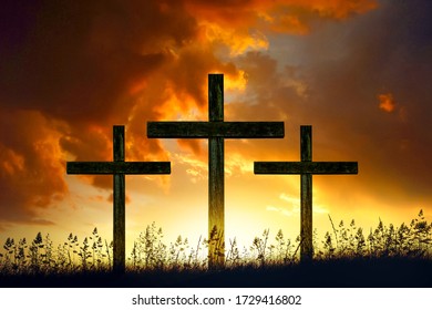 three wooden crosses at sunset sky