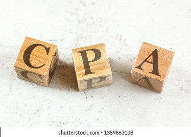 Three wooden cubes with letters CPA (stands for Cost per Action / Acquisition) on white board.