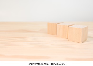 Three Wooden Cubes For Your Text, Icons, Sign And Symbols To Create Your Creative Concepts. Mock Up Blank Wooden Cubes. Blocks On Wood Table
