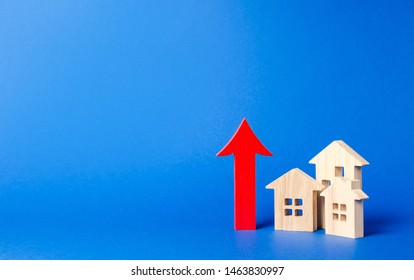 Three Wooden Houses And Red Up Arrow. High Rates Of Construction, High Liquidity. Supply And Demand. Prices For Housing, Building Maintenance. Limit On High-rise Buildings. Real Estate Value Increase.