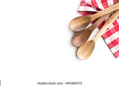 Three wooden spoons and checkered napkin isolated on white background. Top view.