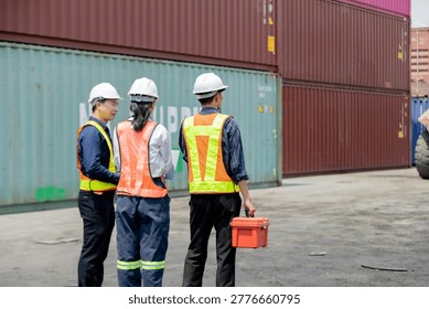 Three workers in safety vests and helmets inspect shipping containers at a port, focusing on logistics or safety procedures.