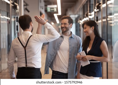 Three Workers Standing In Office Hallway Talking, Millennial Guys Caucasian Businessmen Colleagues Meet Greeting Glad To See Each Other Giving High Five Gesture Of Respect Friendly Relations Concept