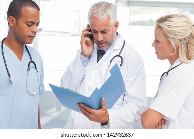 Three worried doctors calling someone - Powered by Shutterstock