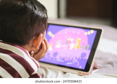 three year old Asian boy at home bed using digital tablet computer - Powered by Shutterstock