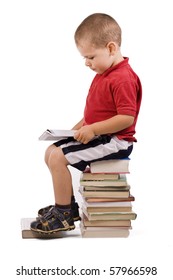 Three Year Old Boy Sitting On Pile Of Books, Reading