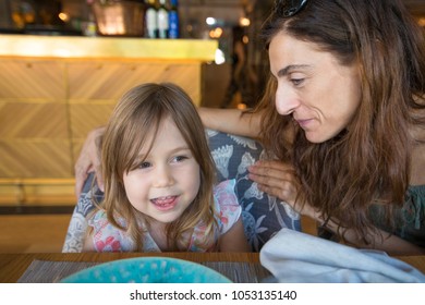 Three Years Old Blonde Girl And Woman Mother Sitting In Restaurant Talking