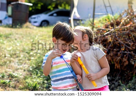 children playing in the sand, having a conversation over sand toys