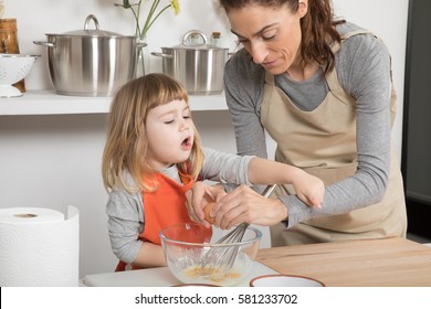 Three Years Old Child And Woman Mother With Beige Apron, In Teamwork, Cooking A Sponge Cake At Kitchen Home- Angry Kid Complaining