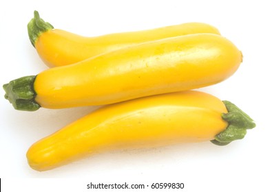 Three Yellow Zucchini Squash  On White Cutting Board