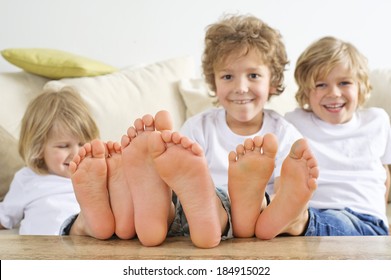 Three Young Boys Have Their Feet On The Table