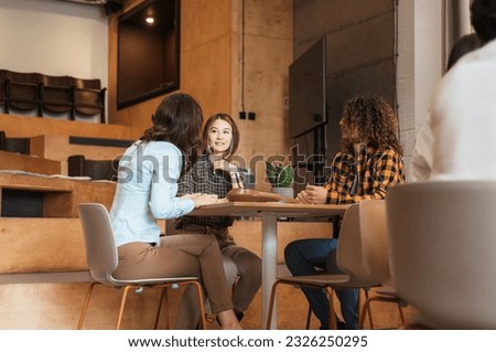 Three young business colleagues sat together at the office