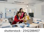 Three young businesswomen are excitedly pointing at a laptop screen, celebrating a positive outcome based on the charts and data they are analyzing in a modern office environment