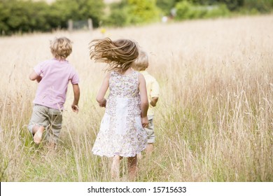 Three Young Children Running Outdoors