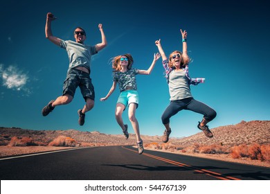 Three young friends jumping and having fun on the empty asphalt road - Powered by Shutterstock