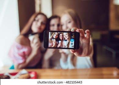 Three young girls are doing selfie in fast food restaurant - Powered by Shutterstock