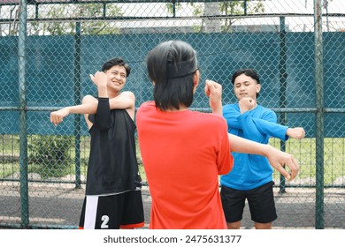 Three Young Men Stretching Their Arms Doing Warming Up On A Sport Court - Powered by Shutterstock