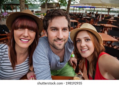 Three Young People In Cafe Taking Selfie.